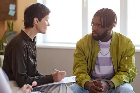 Counselor taking notes while talking with a client